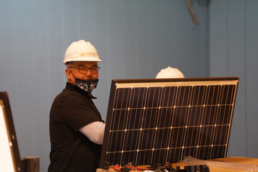 workers working on and installing a solar panel at the quinault indian nation.